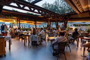 terraza al atardecer con mesas y comensales disfrutando de la velada
