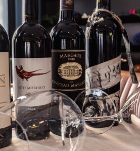 Selección de vinos exclusivos en Ses Oliveres Port de Sóller, con botellas de Château Margaux, Gaja Sito Moresco y La Faraona.